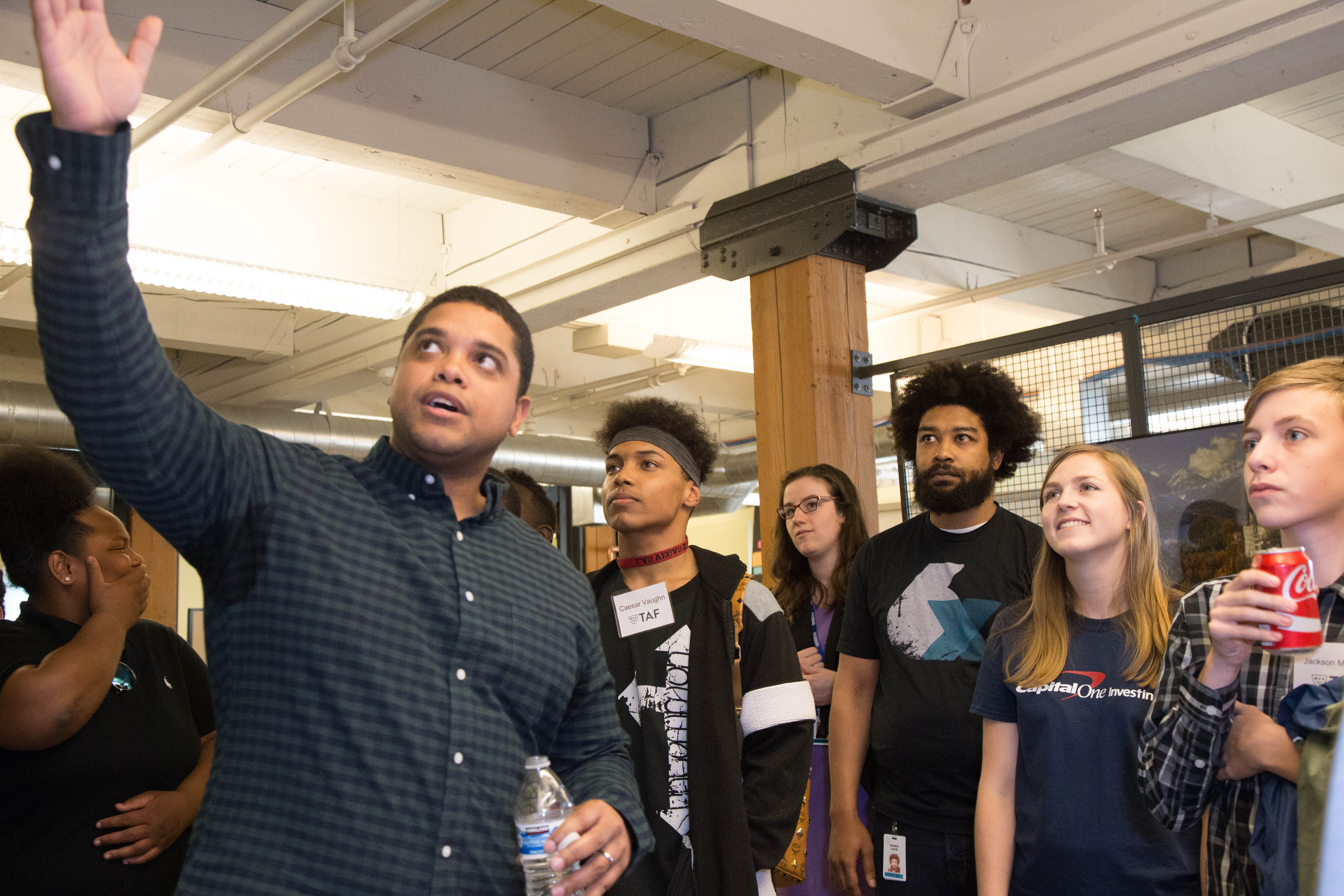 Shortly after arriving at Capital One’s downtown Seattle offices, the TAF students were led on a workspace tour by local associates including Mike Bailey (foreground), Natalie Griffin (fourth from right), Perris Davis (third from right) and Alison Wyllie (second from right.)