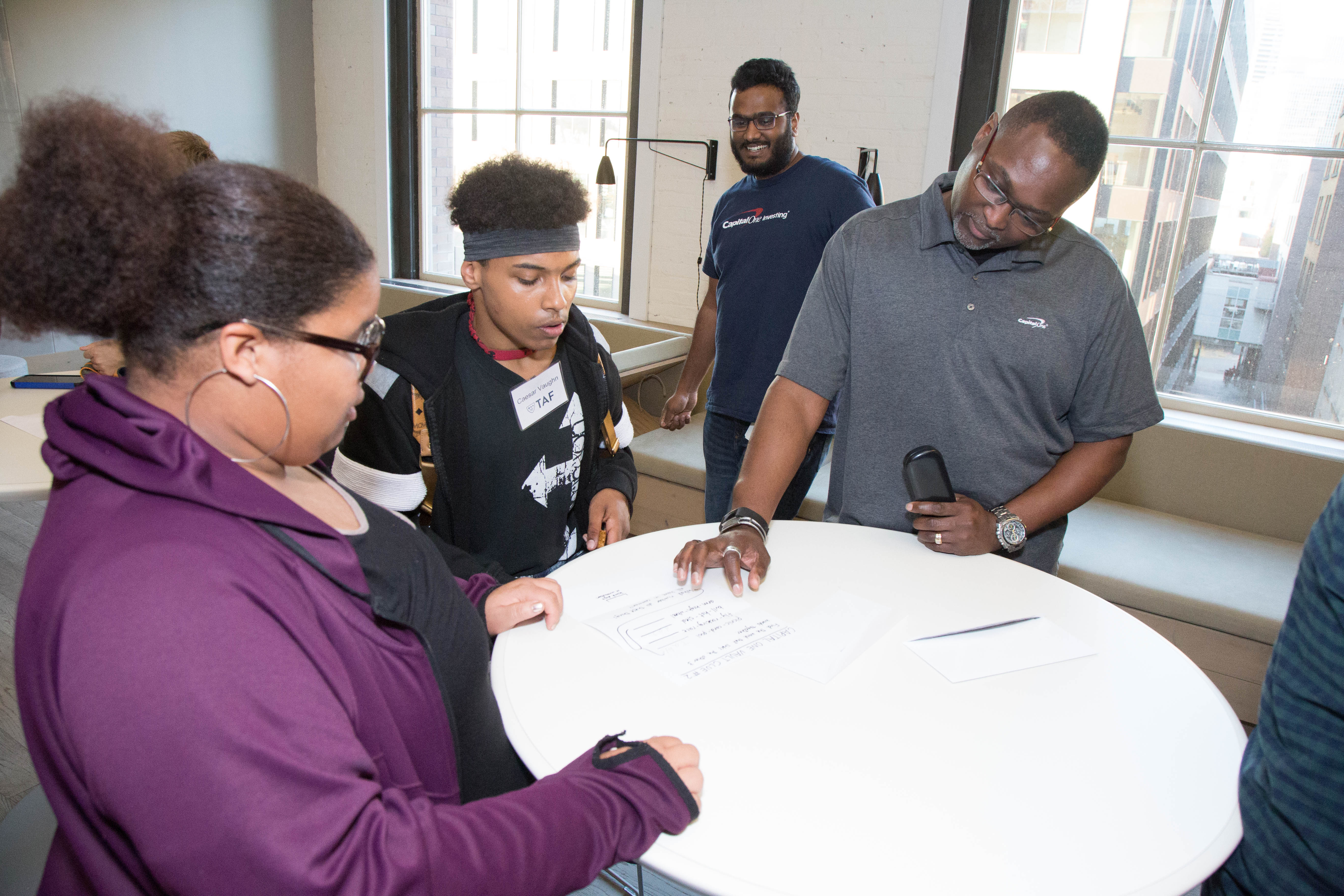 Capital One’s Tony Wilson (foreground, in grey shirt) and Nagkumar Arkalagud were among the Seattle associates who discussed their roles at Capital One and hosted TAF students, each 13-years-old, during a TAF onsite visit to Capital One’s downtown Seattle offices Oct. 26. With Tony and Nagkumar are, from left, Looche’ Brown and Caesar Brown.