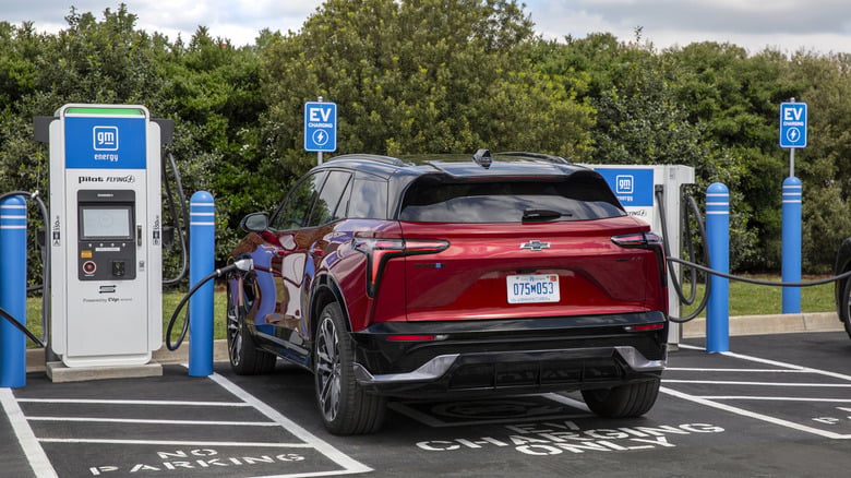 A red GM crossover EV parked at a GM Energy charging station