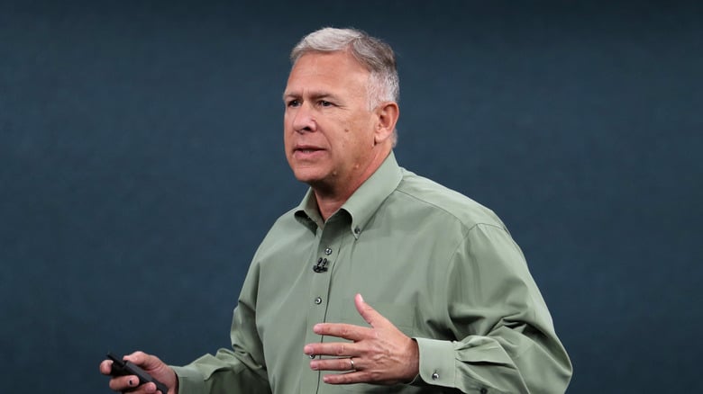 Apple executive Phil Schiller speaking onstage with a presentation clicker in his hand