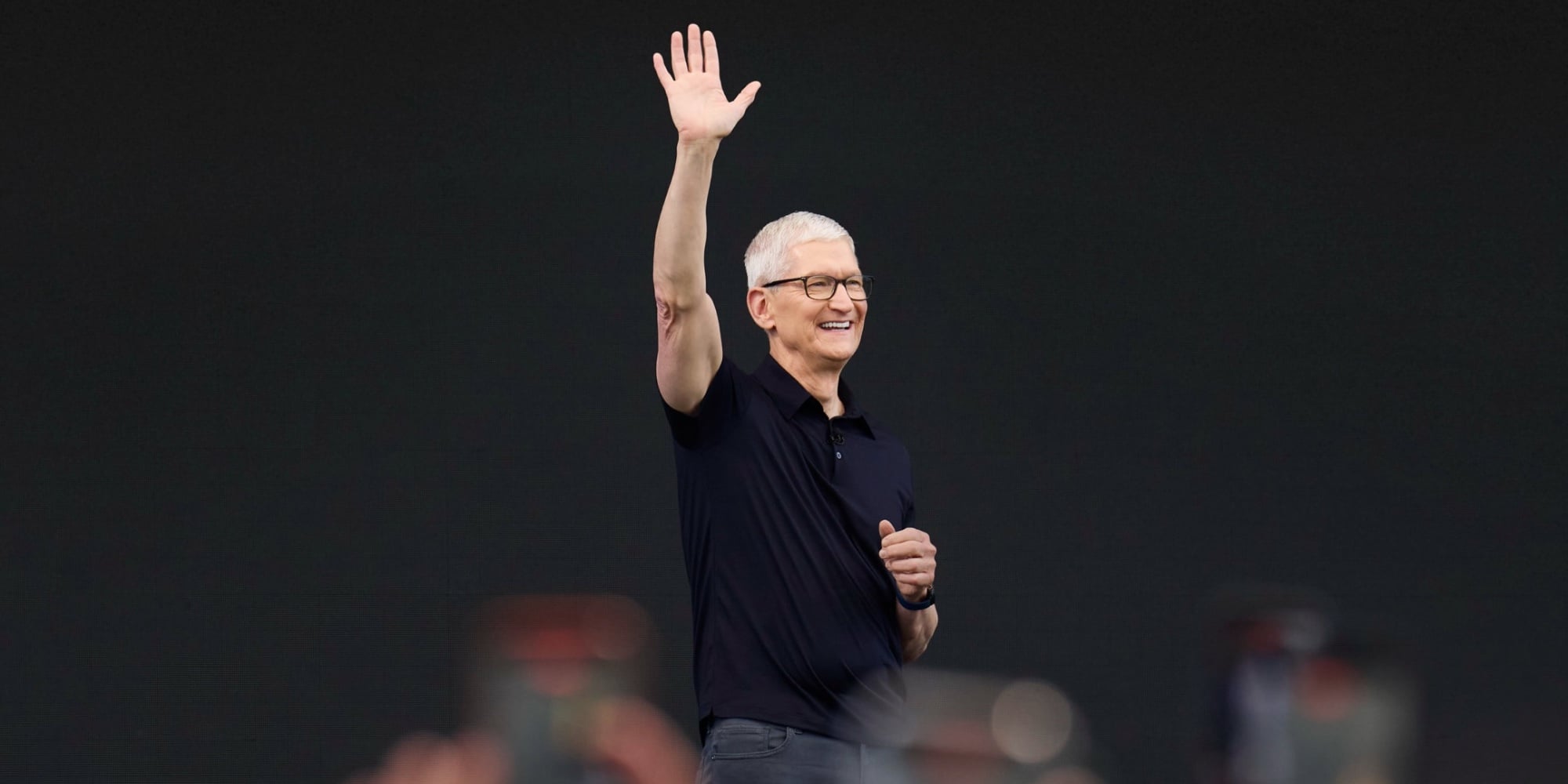 Apple CEO Tim Cook waving on stage at a keynote