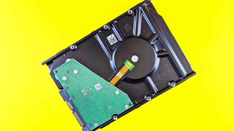 A stack of internal 3.5-inch hard drives next to SSDs, the drives whose prices doubled in 2026