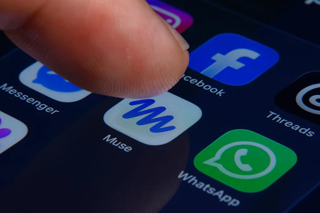 A finger tapping the Meta Muse app on a smartphone screen